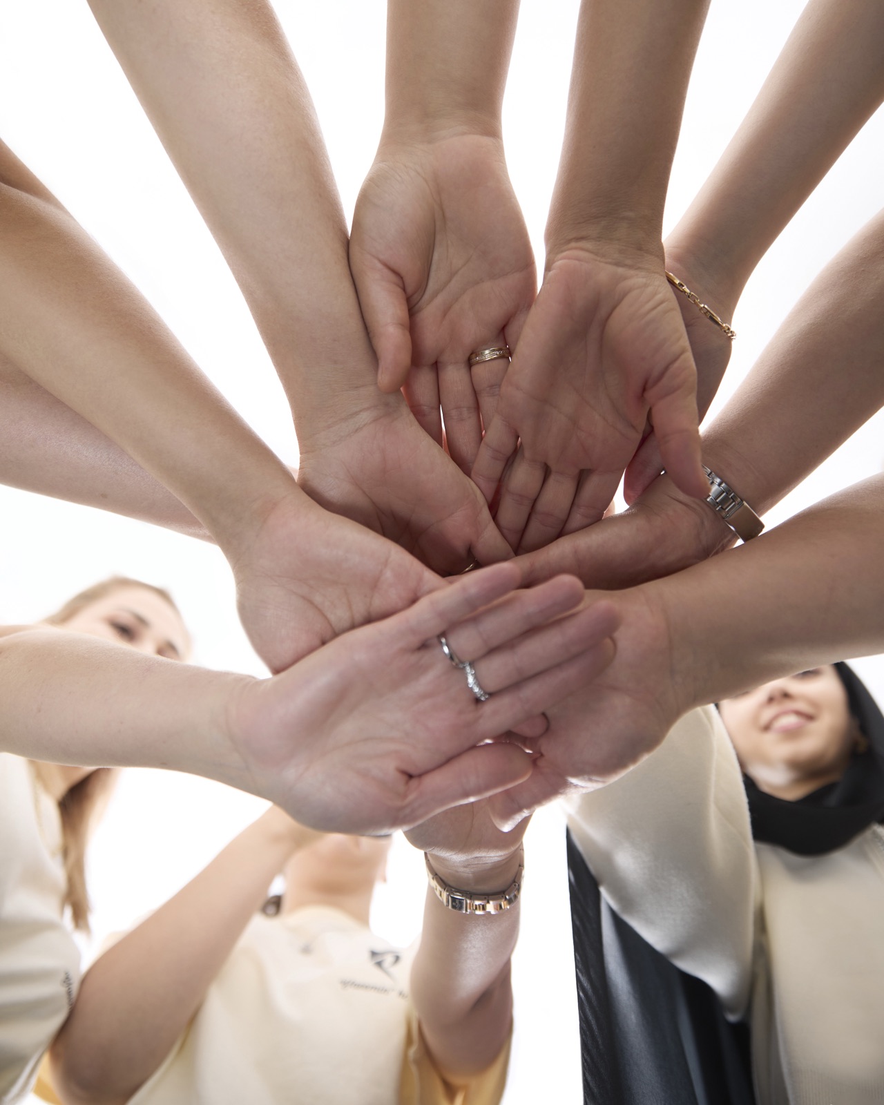 Hands of the Yasemin team stacked together in a gesture of trust