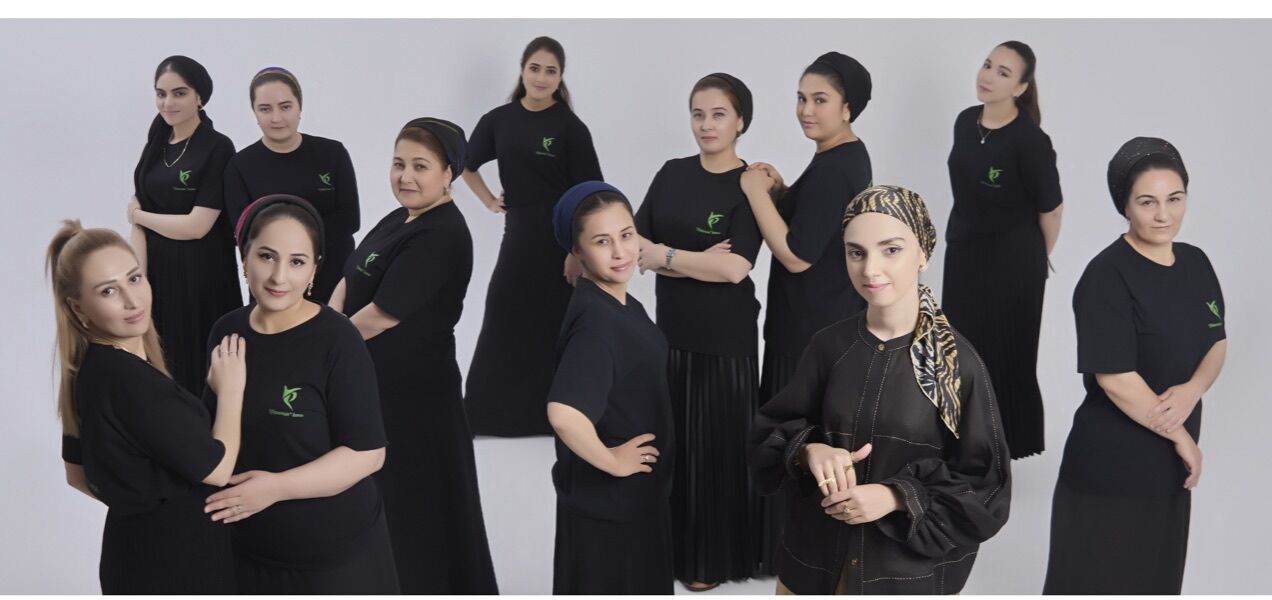 The Yasemin workshop team in black uniforms, posed together on a studio backdrop
