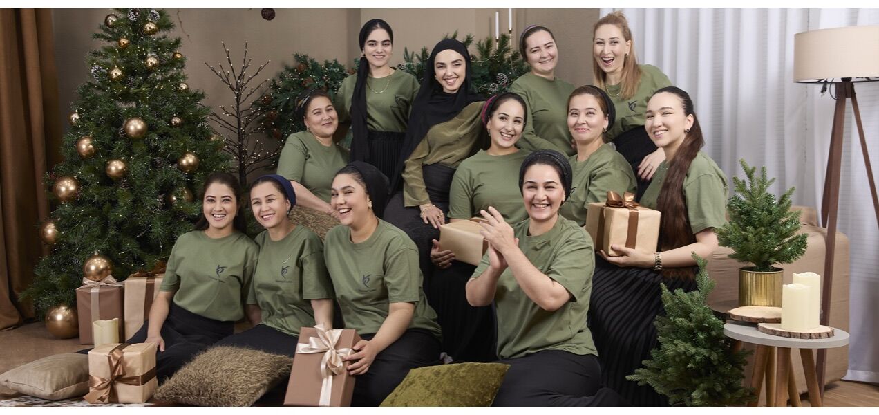 Yasemin team in olive uniforms gathered around a holiday tree with wrapped gifts